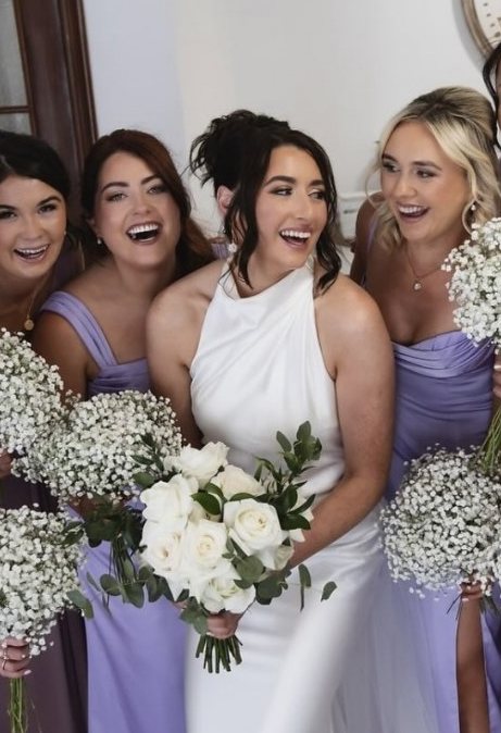 Bride laughing with her bridesmaids, all styled by The Hair Fairy