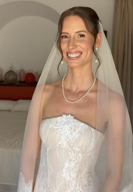 Smiling bride with a veil and pearl necklace